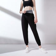 Model wearing black and gray high waist active pants, ideal for workouts and stylish comfort.