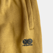 Close-up of Men's Future Summit Fleece Trouser in mustard with logo detail. Ideal for outdoor activities.