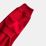 Close-up of red fleece trouser cuff showcasing soft material and ribbed detail. Perfect for warmth and comfort in outdoor activities.