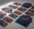 Folded custom sublimated team jerseys and tracksuits in navy and orange for a bulk sports uniform order